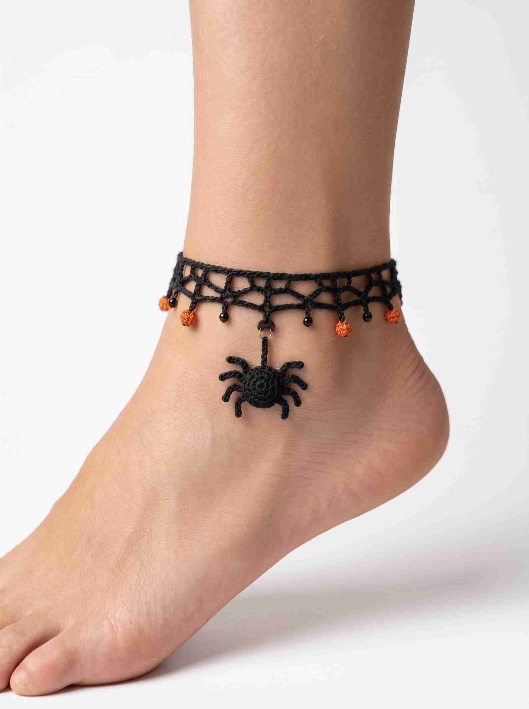 Black crochet spider anklet with delicate lace band, orange and black dangling beads, and a handmade spider charm.